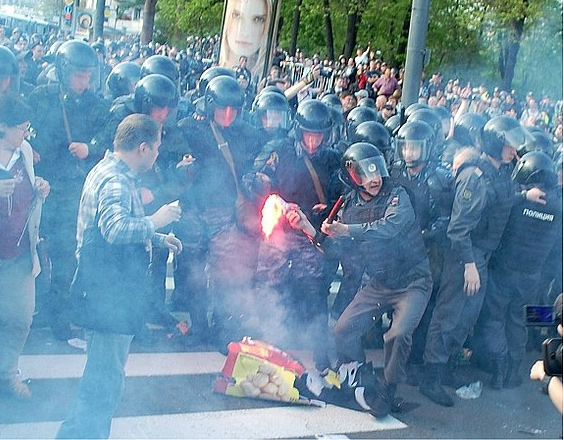 Полицейский бросает горящий фаер в протестующих (6 мая, Болотная площадь)